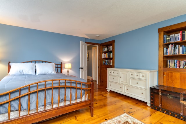 bedroom featuring light wood-type flooring and a textured ceiling