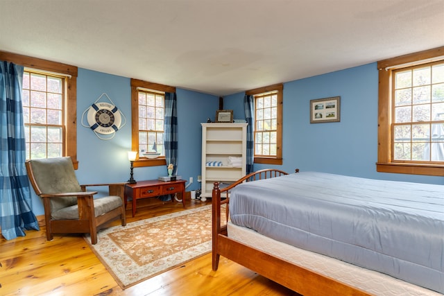 bedroom featuring multiple windows and hardwood / wood-style floors