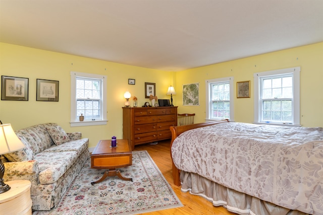 bedroom featuring multiple windows and light hardwood / wood-style flooring