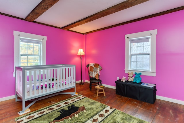 bedroom with beamed ceiling and dark hardwood / wood-style flooring