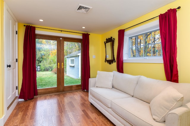 living room featuring french doors, hardwood / wood-style flooring, and a healthy amount of sunlight