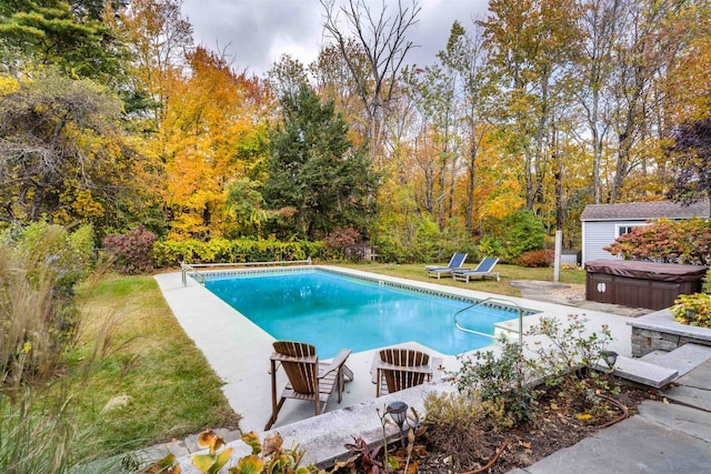 view of pool with a hot tub, a yard, and a patio area