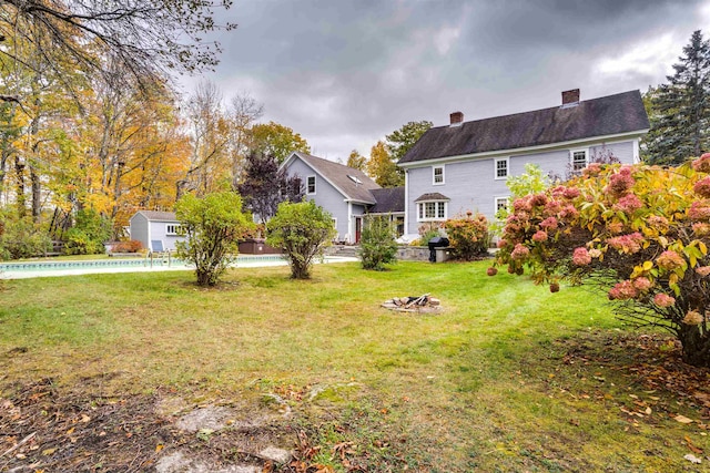 view of yard featuring an outdoor fire pit and a pool