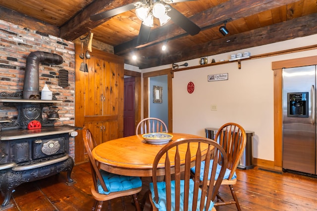 dining room with a wood stove, beamed ceiling, wooden ceiling, and wood-type flooring