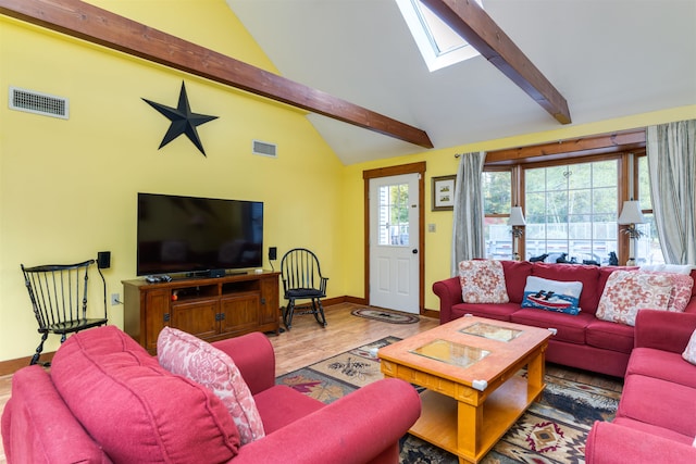 living room with a skylight, hardwood / wood-style flooring, beamed ceiling, and high vaulted ceiling