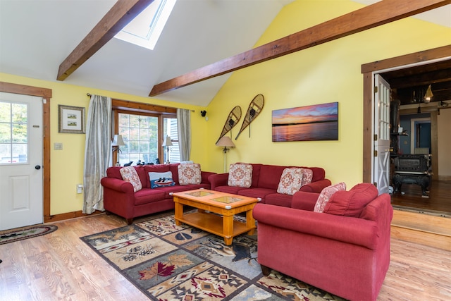 living room featuring wood-type flooring and lofted ceiling with skylight