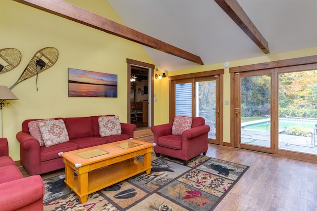 living room featuring ceiling fan, hardwood / wood-style flooring, and lofted ceiling with beams