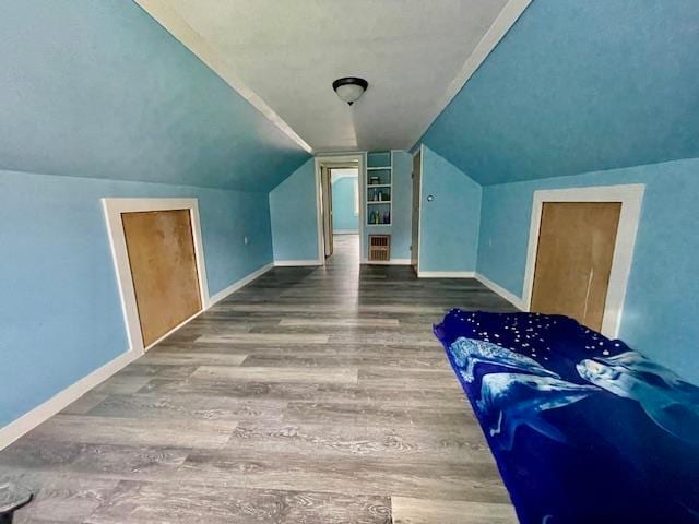 bonus room with hardwood / wood-style floors and vaulted ceiling