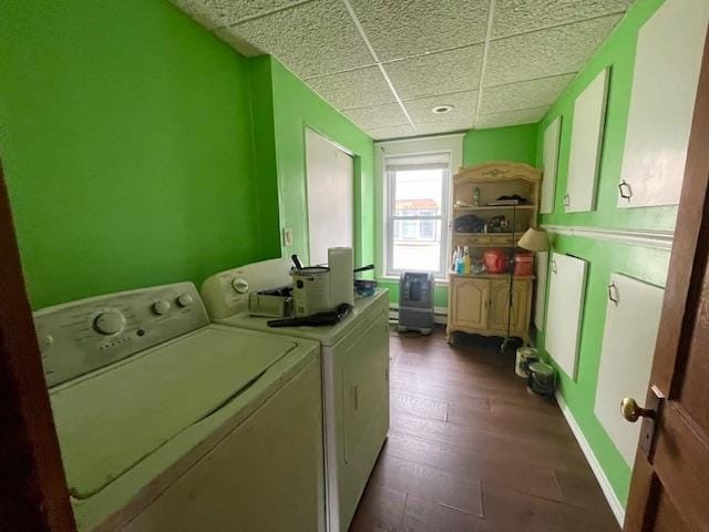 washroom with washing machine and dryer, wood-type flooring, and cabinets