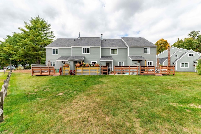 rear view of house featuring a wooden deck and a yard