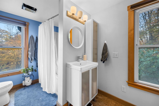 bathroom with a shower with shower curtain, vanity, and toilet