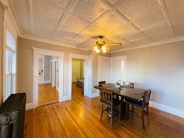 dining space featuring light hardwood / wood-style flooring, ornamental molding, and ceiling fan