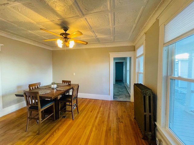 dining space featuring hardwood / wood-style floors, radiator, and ceiling fan