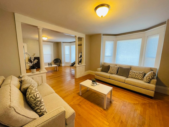 living room featuring wood-type flooring and ornate columns