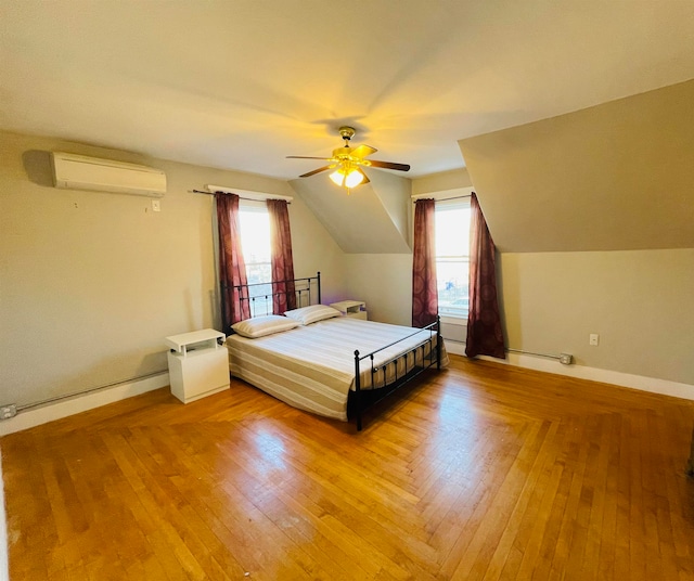 unfurnished bedroom featuring multiple windows, an AC wall unit, lofted ceiling, and ceiling fan