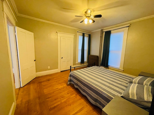 bedroom with crown molding, light wood-type flooring, and ceiling fan