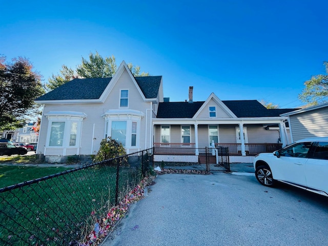 view of front of home with covered porch and a front lawn