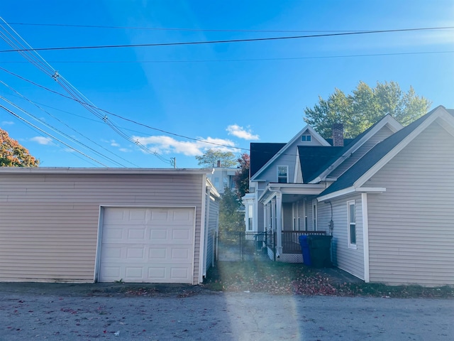 view of property exterior with an outdoor structure and a garage