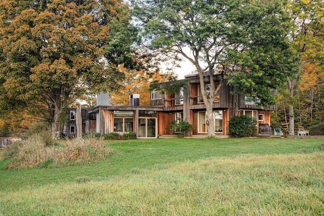 rear view of house featuring a yard