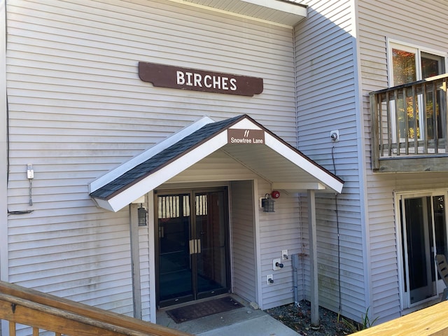 view of exterior entry featuring a balcony