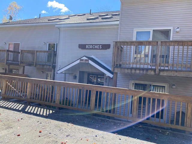 rear view of property with a balcony and a deck