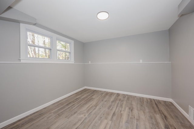 unfurnished room featuring light hardwood / wood-style floors and lofted ceiling