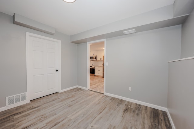 spare room featuring light hardwood / wood-style flooring