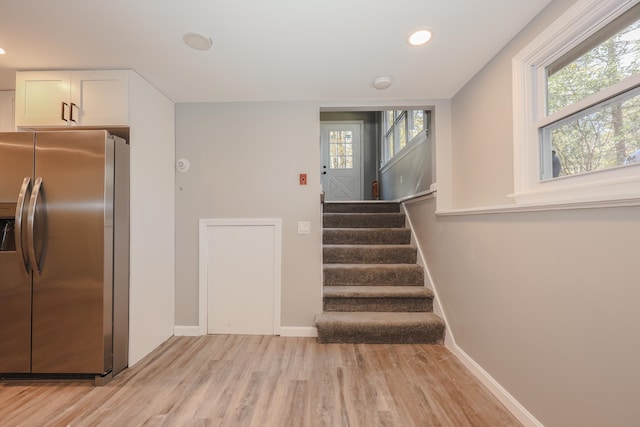 stairway with hardwood / wood-style flooring and a healthy amount of sunlight