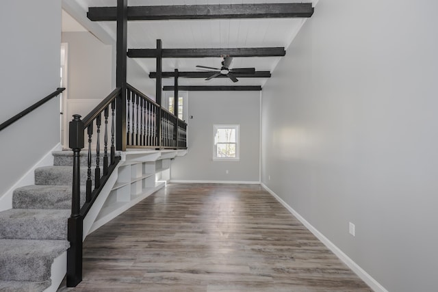 stairway with ceiling fan, hardwood / wood-style flooring, and lofted ceiling with beams