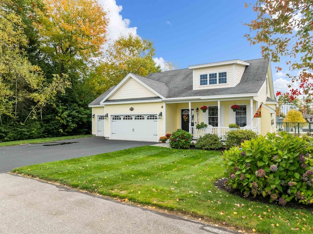 view of front of home with a front yard, a porch, and a garage