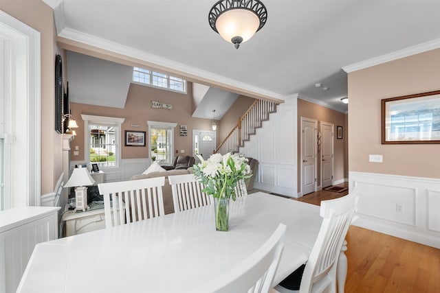 dining room with ornamental molding and light wood-type flooring