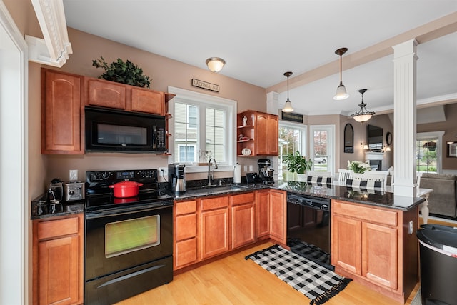 kitchen featuring light wood-type flooring, black appliances, ornate columns, pendant lighting, and sink