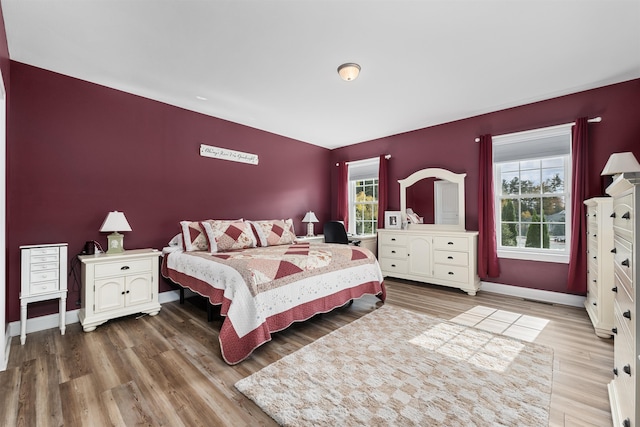 bedroom featuring multiple windows and hardwood / wood-style flooring