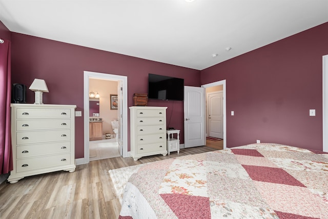 bedroom with light hardwood / wood-style flooring and ensuite bathroom