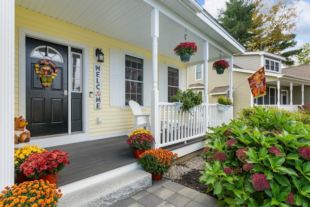 view of exterior entry featuring covered porch