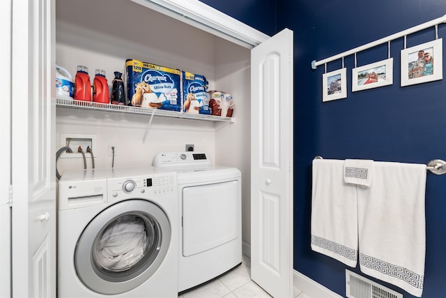 laundry room with washer and dryer and light tile patterned flooring