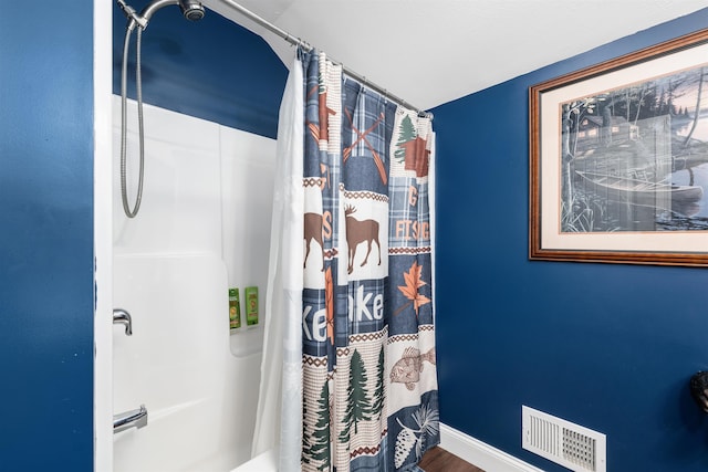 bathroom with hardwood / wood-style flooring and a shower with curtain