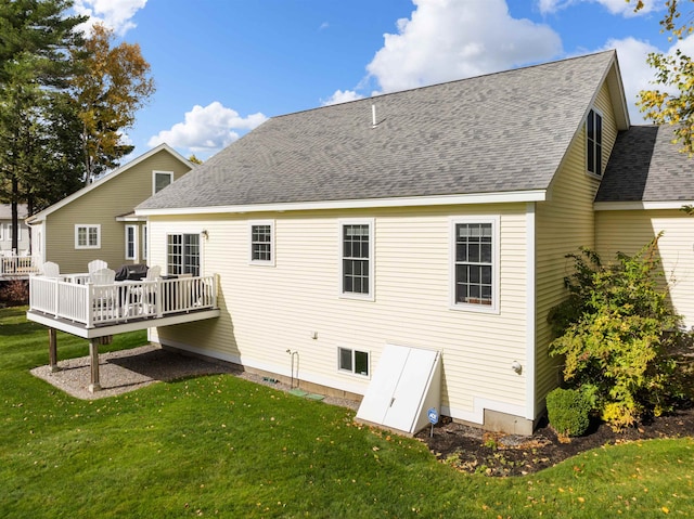 rear view of property with a wooden deck and a lawn