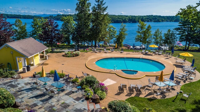 view of swimming pool featuring a water view, a patio area, and a hot tub