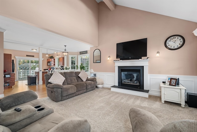 carpeted living room featuring lofted ceiling with beams