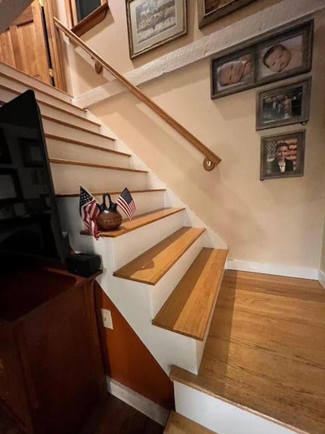 staircase with wood-type flooring