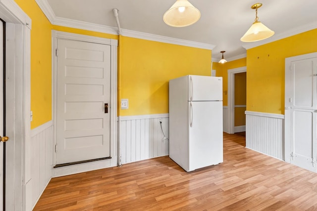 kitchen featuring ornamental molding, light hardwood / wood-style flooring, pendant lighting, and white refrigerator