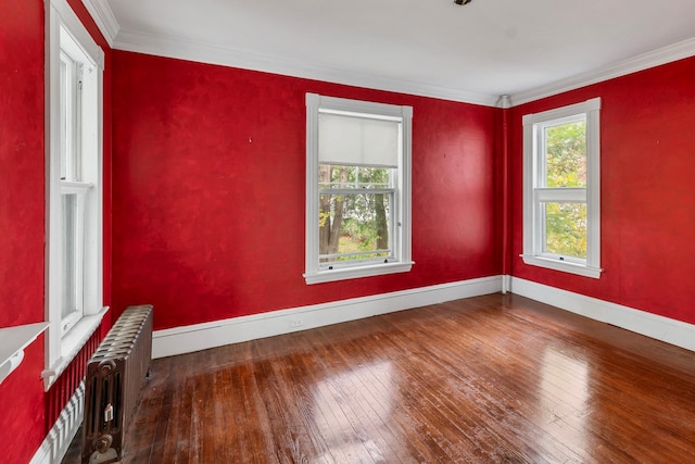 unfurnished room with crown molding, radiator, and wood-type flooring