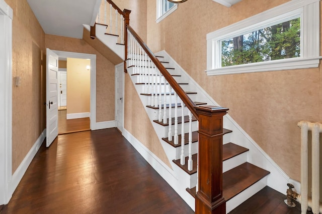 stairs with hardwood / wood-style floors and radiator