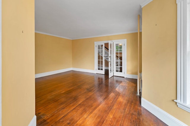 spare room featuring crown molding, dark wood-type flooring, and plenty of natural light