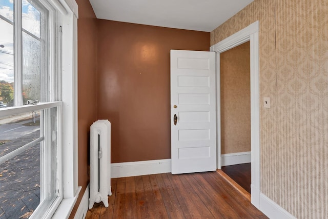 interior space featuring dark wood-type flooring, a healthy amount of sunlight, and radiator