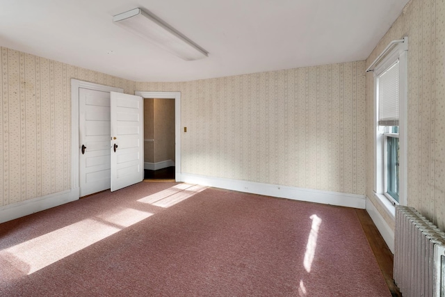 empty room with radiator and carpet floors