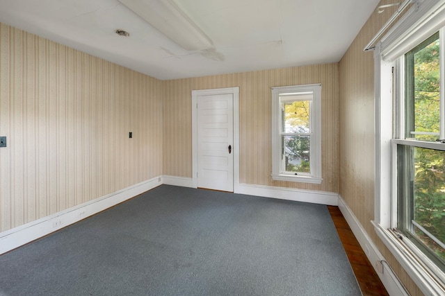 spare room with dark colored carpet