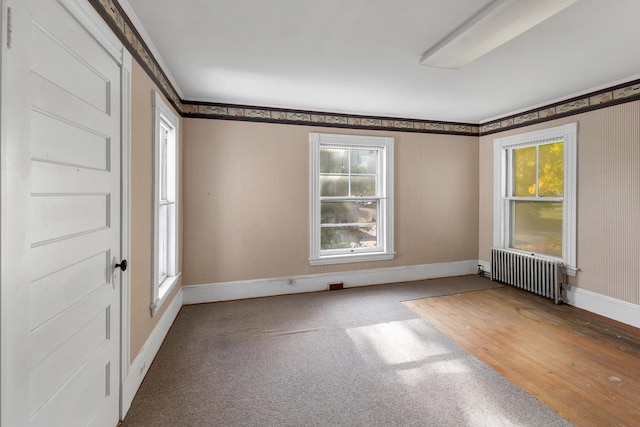 empty room featuring hardwood / wood-style floors and radiator