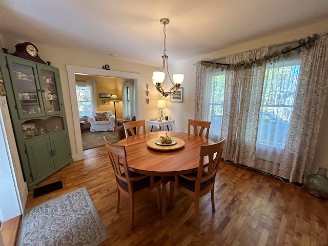 dining area with hardwood / wood-style flooring, a chandelier, and a wealth of natural light